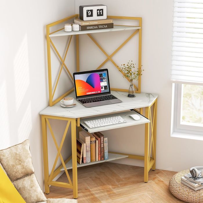 Compact corner desk setup featuring a laptop, keyboard, and a decorative vase. The lower shelf holds books, while the upper shelf features a small clock