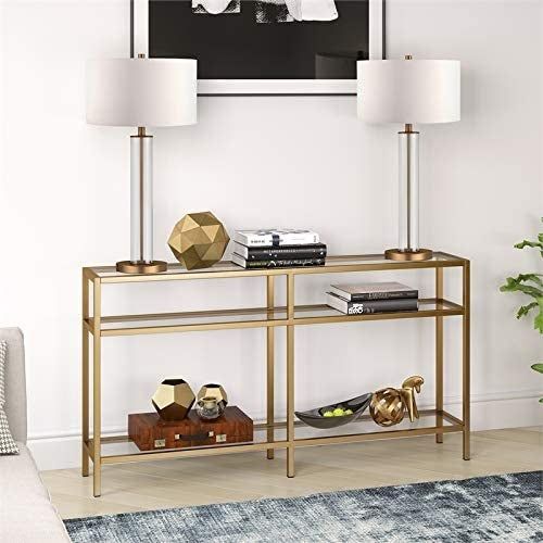 a gold console table with lamps and decorative items placed on it