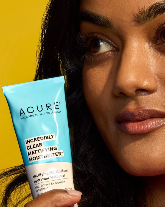 A person holding a tube of moisturizer