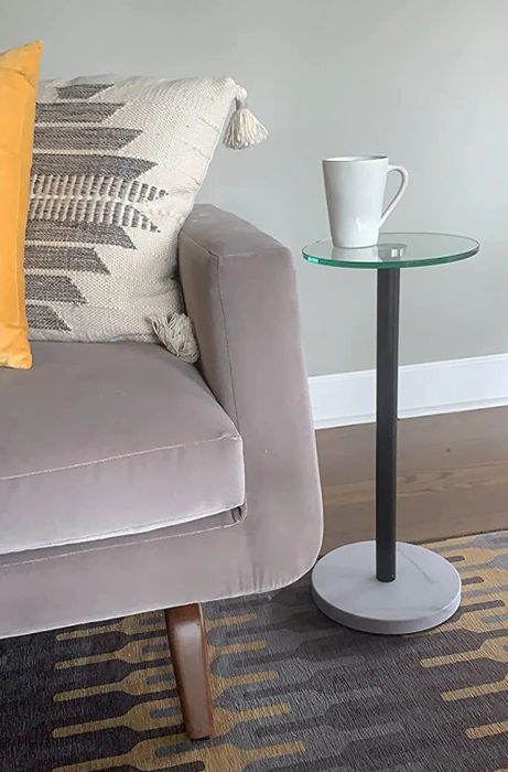 Glass-top table with a marble base in a reviewer's living room