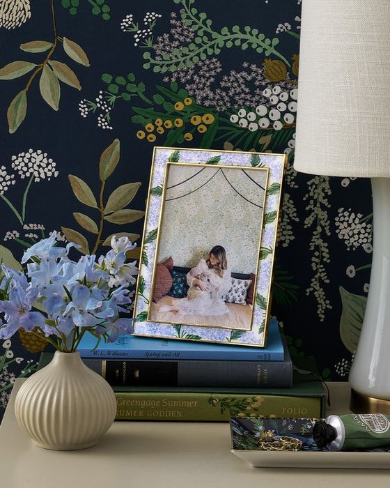 A picture frame adorned with blue hydrangeas surrounding the photo space.