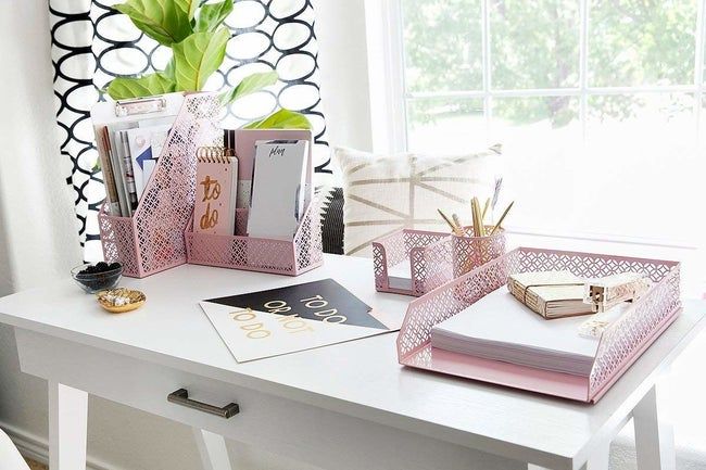 A collection of pink desk accessories neatly arranged on a desk.