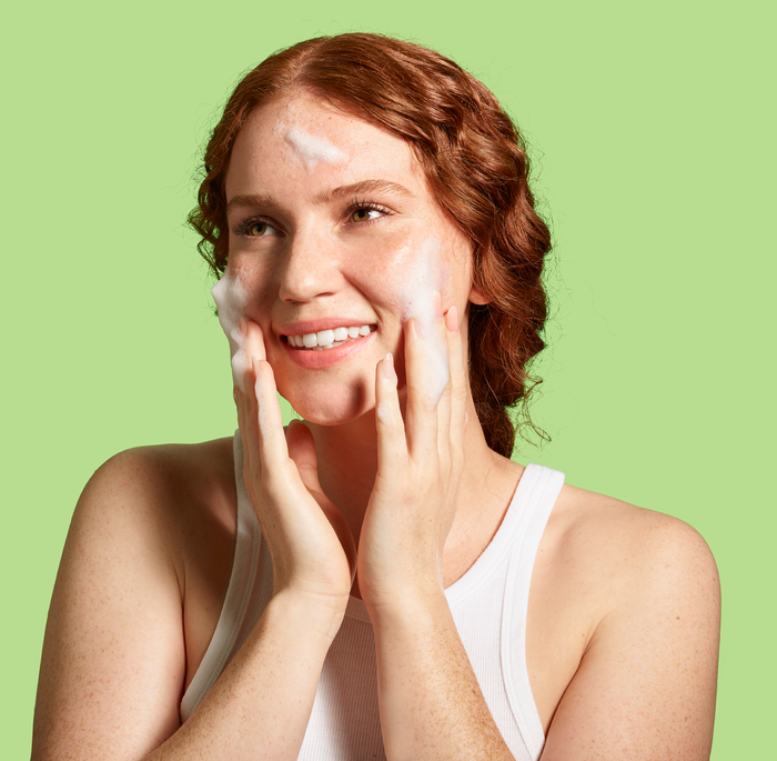 A person washing their face with the foamy cleanser