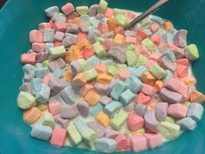 A close-up of marshmallows floating in a bowl of milk.