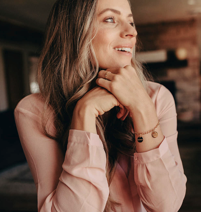 A model showcasing a gold charm bracelet.