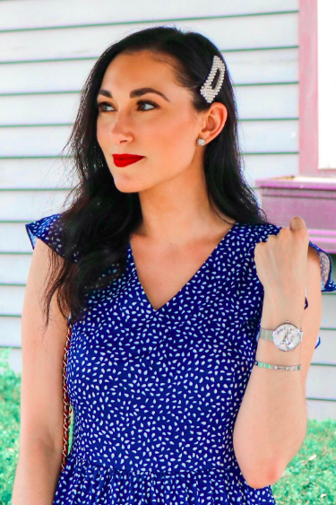 A reviewer wearing a large rectangular pearl clip.