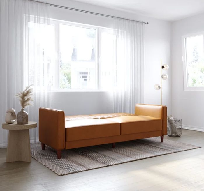 flat faux leather sofa bed resting on four legs