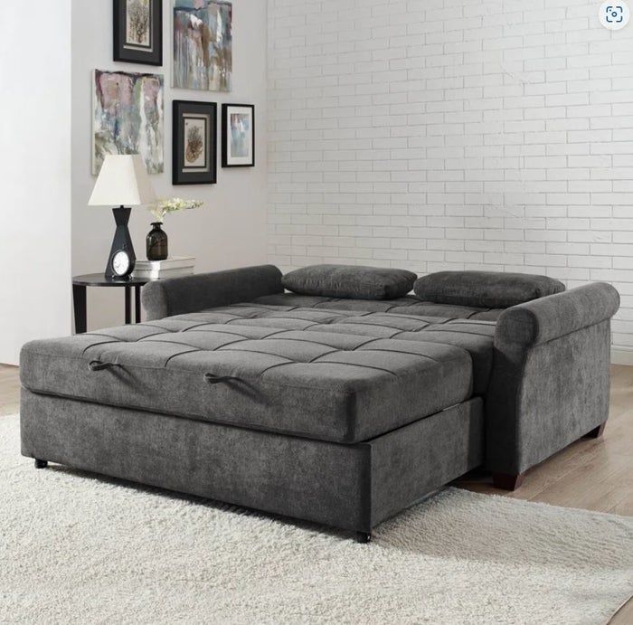large dark grey pull-out sofa bed with cushions and ottoman
