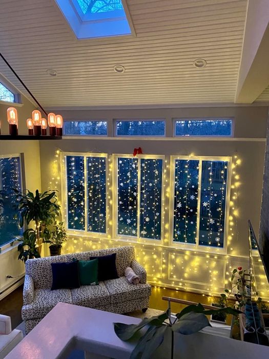 A reviewer's living room with soft, warm white fairy lights draped across the window