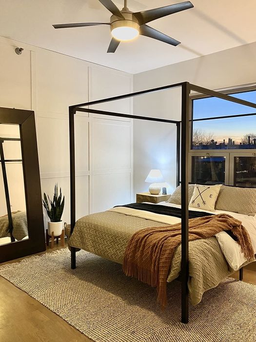 A reviewer's photo of a sleek black four-poster frame