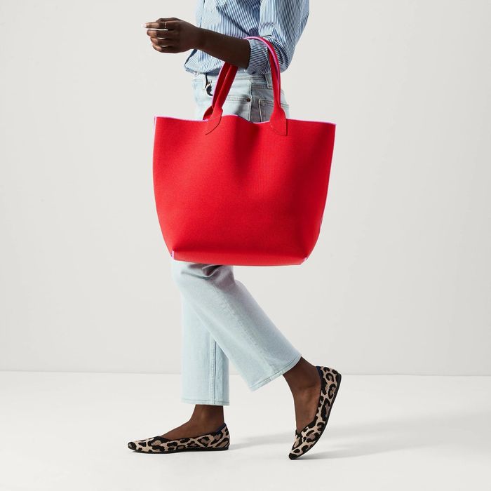 A model showcasing a large red tote bag