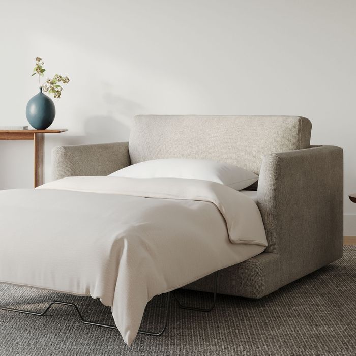 A modern, minimalist bed with neutral bedding, set up in a clean and serene bedroom