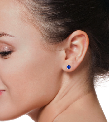 A model wearing stunning blue sapphire stud earrings.