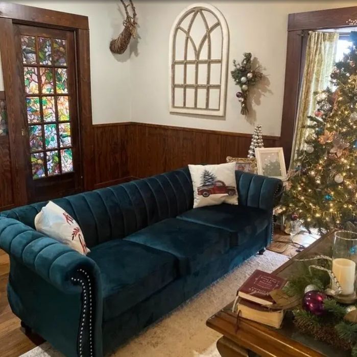 dark teal velvet sofa with graceful curved armrests and sophisticated nailhead detailing