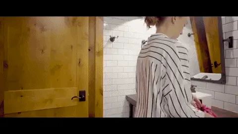 A model unfolding the bag to show how it lays flat with all the makeup neatly organized inside