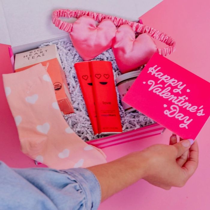 Valentine's gift box containing tea, chocolates, a card, pink socks, and a heart-shaped eye mask