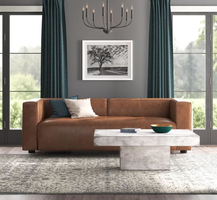 long rectangular brown leather couch with small cushions in the living room