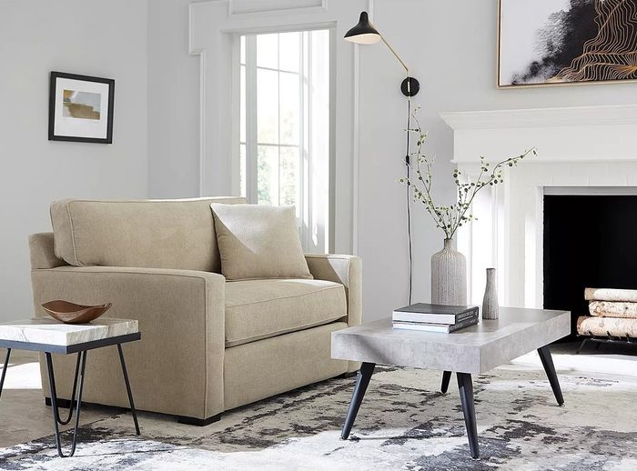 An elegant living room featuring a beige sofa, a coffee table, and decorative accents that create a welcoming atmosphere