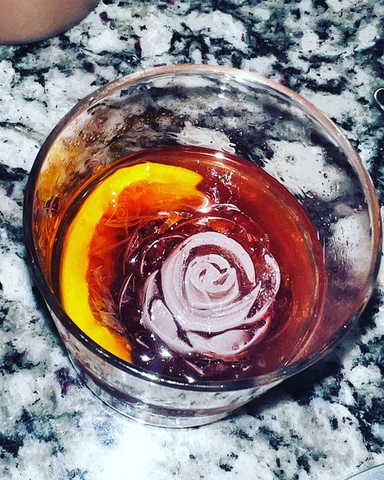 A rose-shaped ice cube in a cocktail.