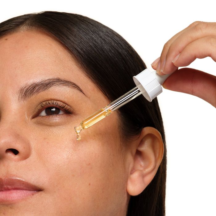 A person applying the serum with a dropper applicator