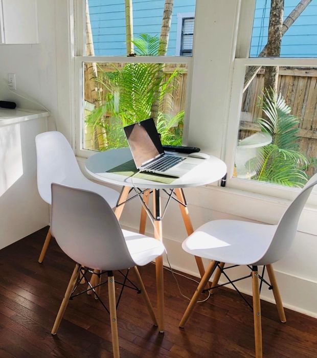 Three white shell chairs in a different reviewer's kitchen setting.