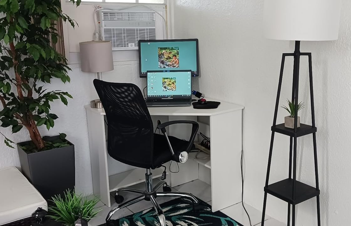 A reviewer's white desk in their room with two computers placed on top