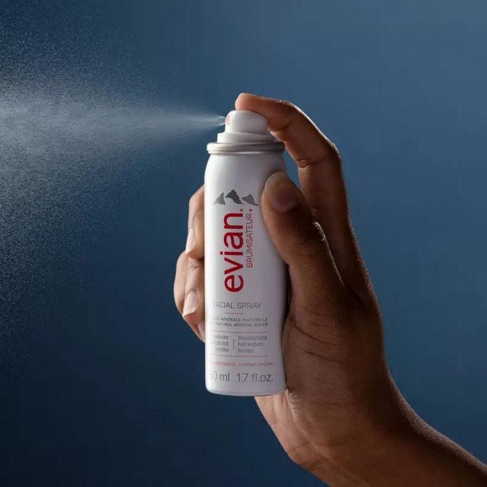 Person holding the spray bottle, misting the air