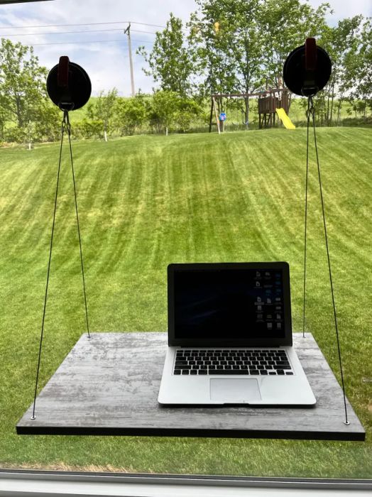 A suction cup desk mounted on a window.
