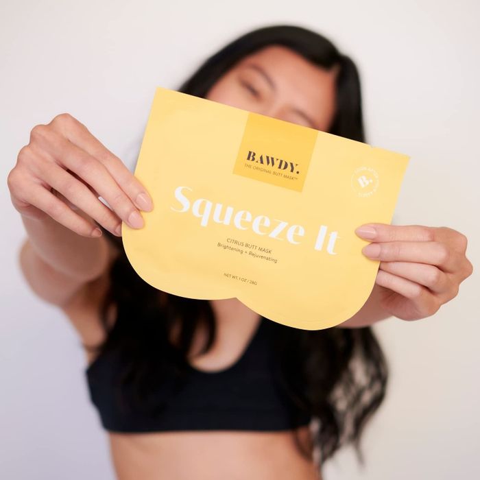 A model holding up a yellow butt mask that reads.