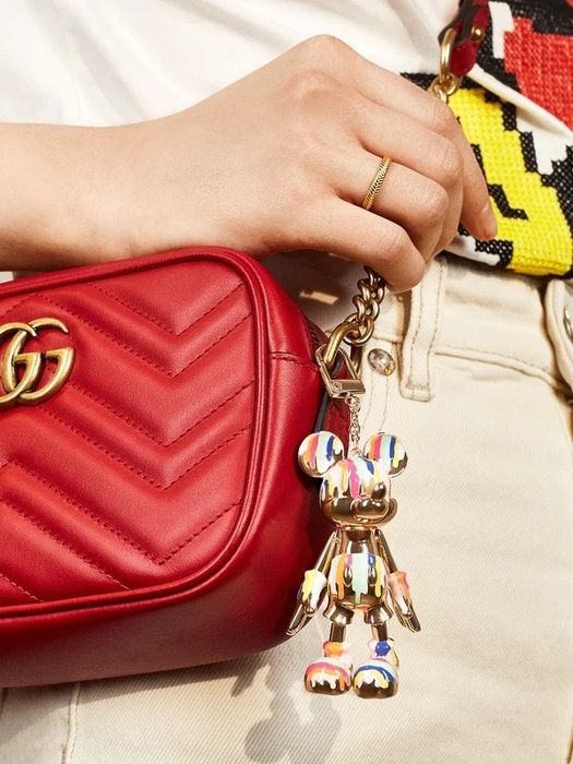 A gold Mickey keychain with artistic paint drips on it, adding a unique flair.