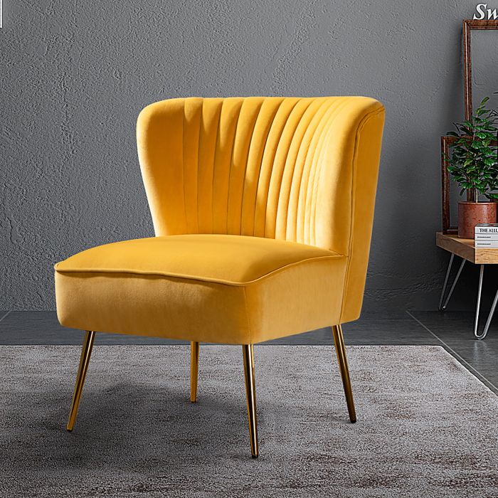 A vibrant yellow velvet chair with pleated detailing on the backrest and elegant gold legs.