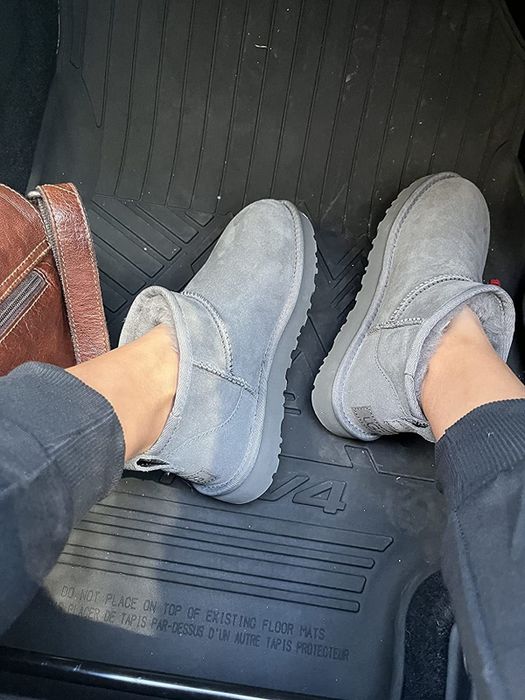 A reviewer wearing ankle-length, mini gray Ugg boots