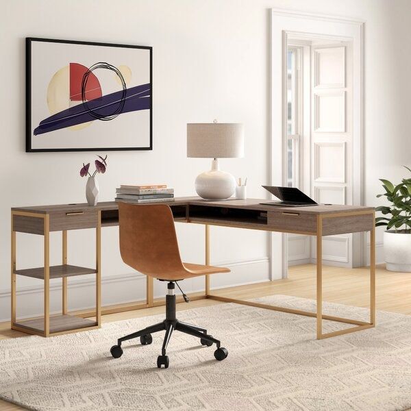 The wood and gold L-shaped desk, adorned with books and a laptop on top