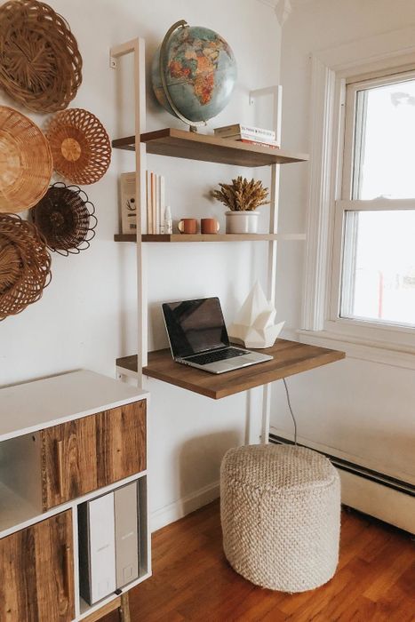 A boho-style office with a white-piped, wood-shelf-mounted ladder desk