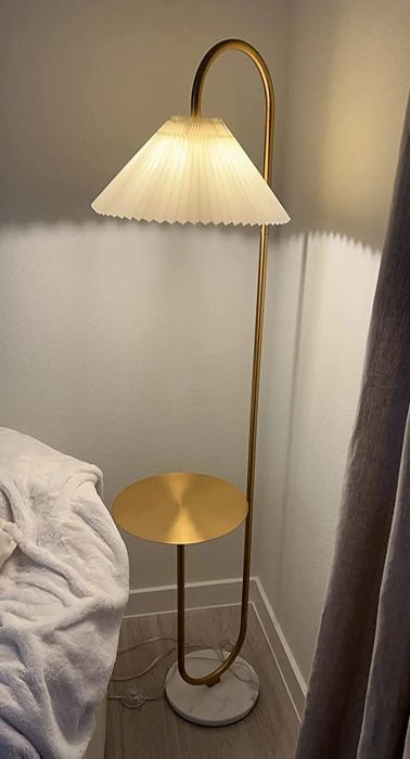 A gold lamp with a cream shade in the reviewer’s home.