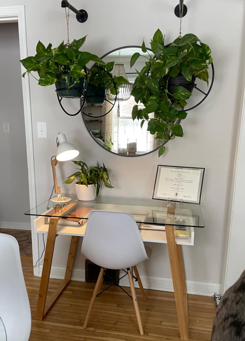A chair positioned next to a glass writing desk