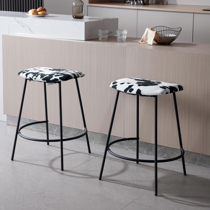 Two bar stools with cow print seats placed in front of a kitchen island, offering a modern home decor vibe.