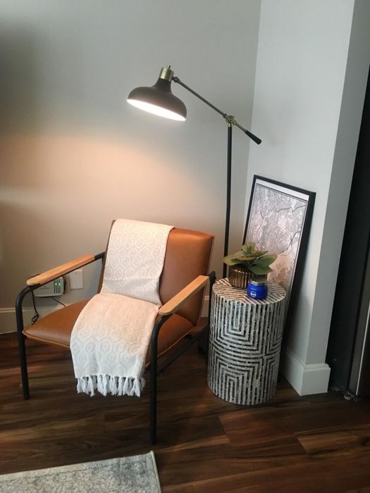 a reviewer's tan chair with a cozy throw blanket draped over it