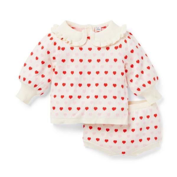 A newborn sweater set adorned with little hearts and a collar.