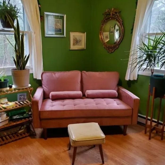 pink tufted small loveseat placed in a cozy living room