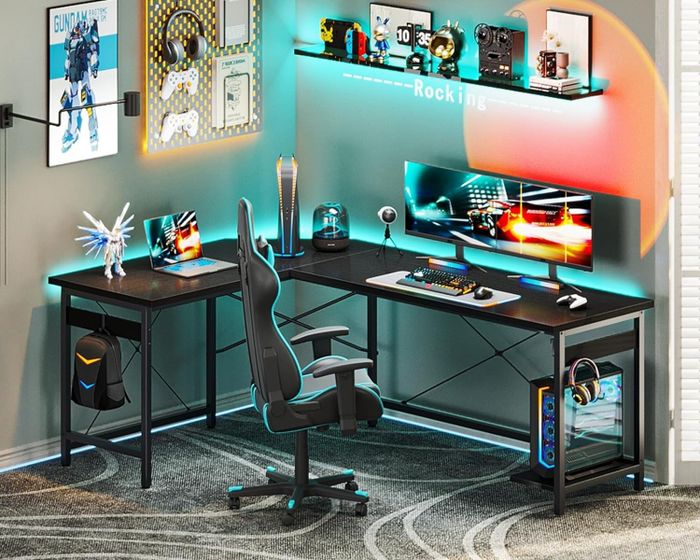 A modern gaming setup featuring dual monitors, a gaming chair, gaming PC, and a variety of gaming accessories on shelves, surrounded by decorations and posters in the background