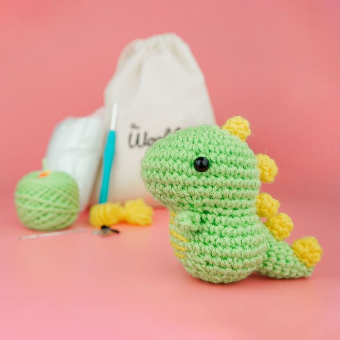 A small, adorable green crocheted dinosaur.