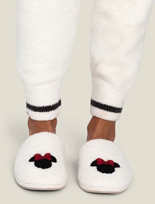 Soft, white slippers featuring an adorable Minnie Mouse icon on them.