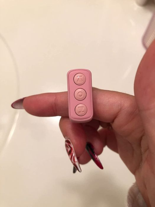 A reviewer showing off the scrolling remote on their finger