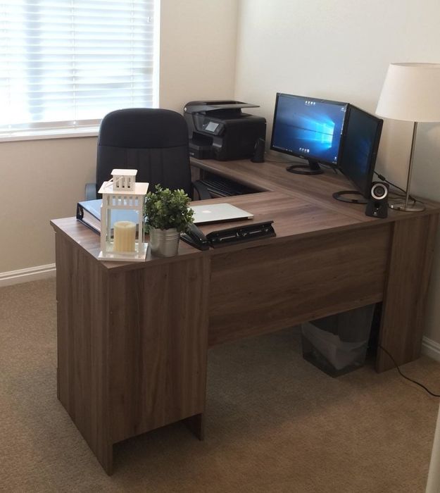 A reviewer’s view of a dark wooden desk with side panels and an office chair in front of it