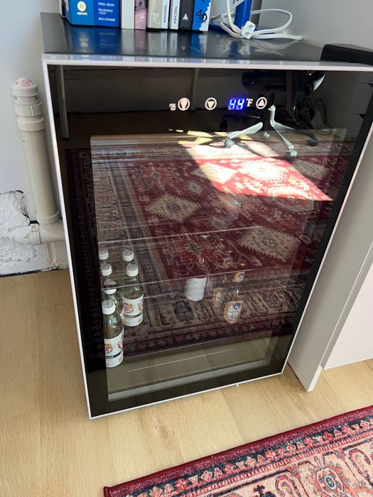 A modern, freestanding beverage fridge with a stylish glass door, offering easy visibility of your drink collection without the need to open it.