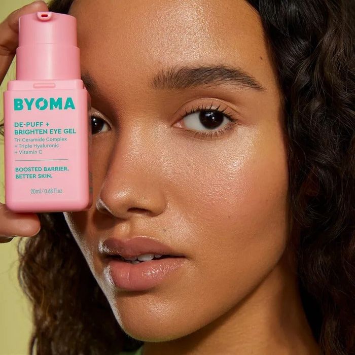 A model holding the eye gel bottle near their face