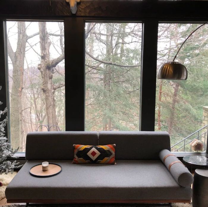 grey pull-out sofa bed in a rustic cabin-inspired living room