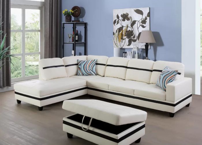 An extra-large, long white L-shaped couch with a middle black stripe and a matching ottoman
