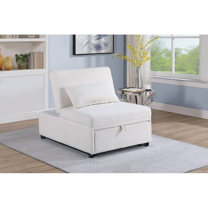 A white plush armless chair with a matching pillow, placed in a chic living room complete with a painting, vases, and a side table for added style.